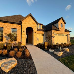 Single-story stone home with a gabled roof and landscaped front yard
